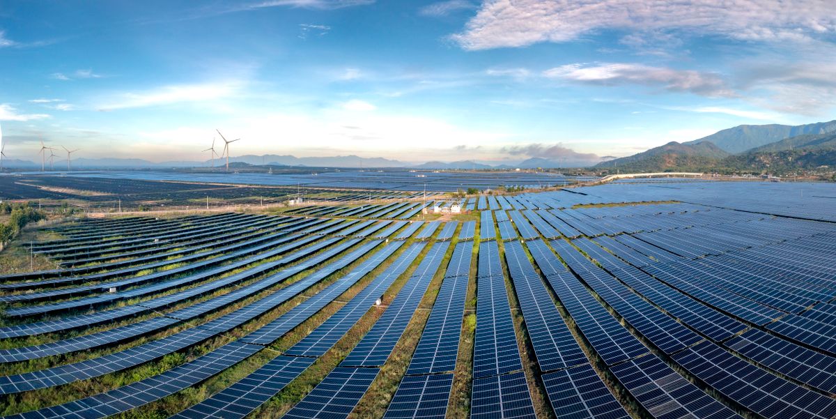 Solar farm with wind turbines on the horizon